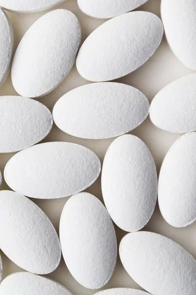 Pile of white drug pills laying on white background — Stock Photo, Image