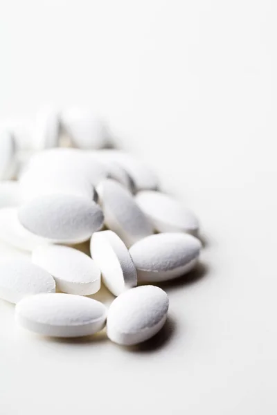 Pile of white drug pills laying on white background. — Stock Photo, Image