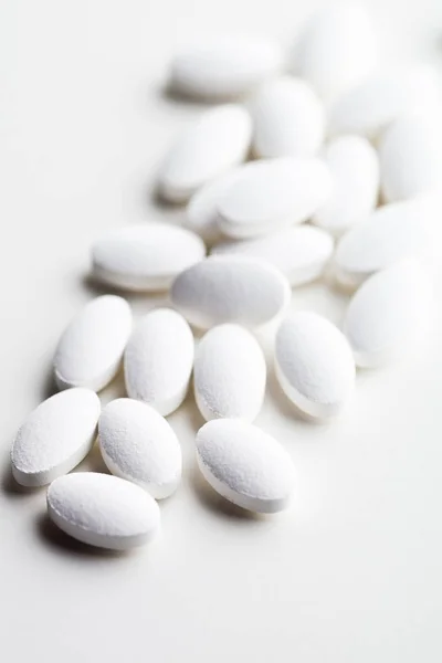 Pile of white drug pills laying on white background. — Stock Photo, Image