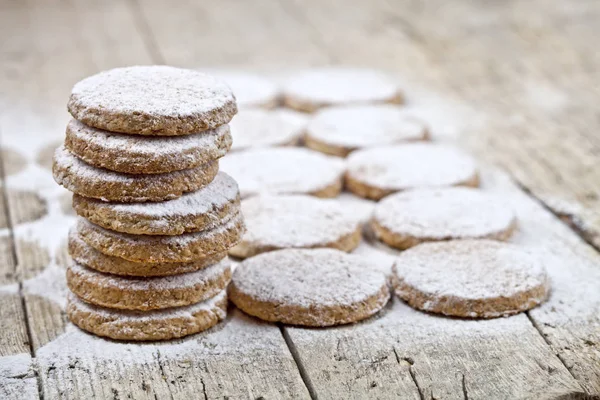 Φρεσκοψημένα μπισκότα βρώμης με σκόνη ζάχαρης σε ρουστίκ ξύλινο τραπέζι — Φωτογραφία Αρχείου