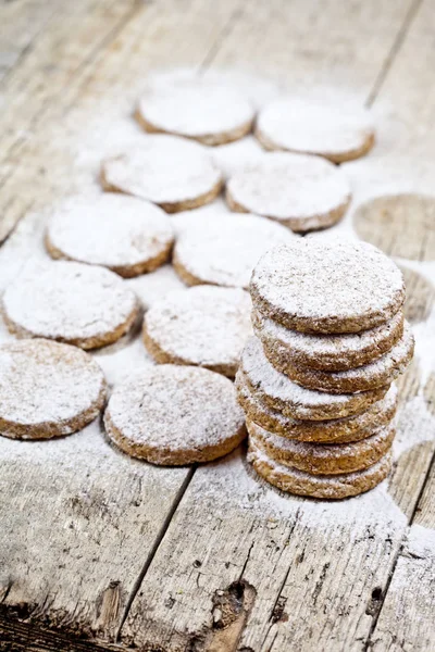 Fresh baked oat cookies with sugar powder on rustic wooden table — Stock Photo, Image