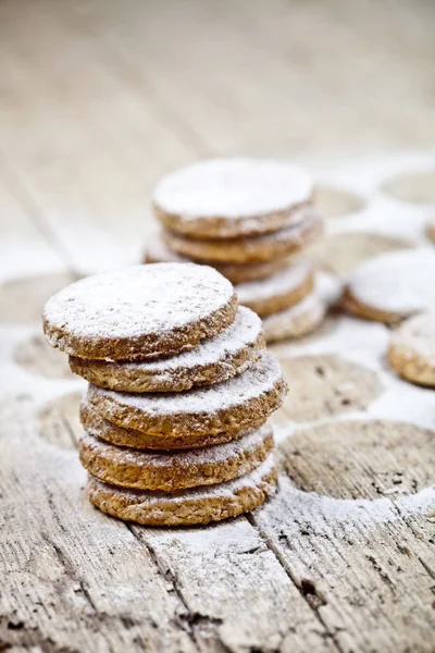 Φρέσκα μπισκότα βρώμης με σκόνη ζάχαρης σε ρουστίκ ξύλινο τραπέζι. — Φωτογραφία Αρχείου