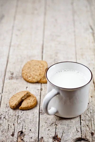 Copa de leche y algunas galletas de avena recién horneadas en rústica ta de madera —  Fotos de Stock