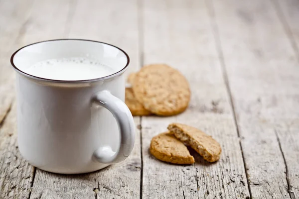 素朴な木製のタにミルクと焼きたてのオート麦クッキー — ストック写真