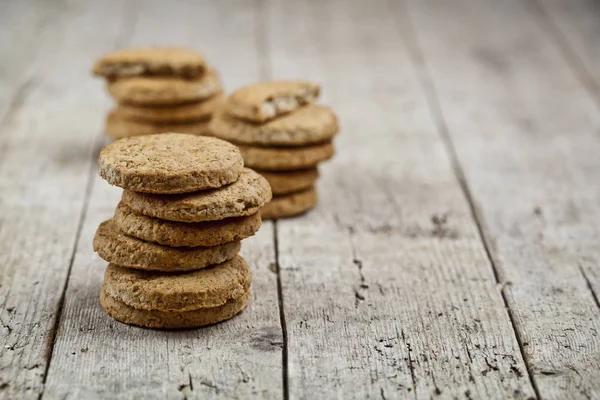 Stacks of fresh baked oat cookies on rustic wooden table backgro — Stock Photo, Image