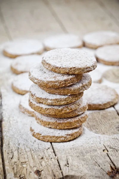 Φρέσκα μπισκότα βρώμης με σκόνη ζάχαρης κοντινό σε ρουστίκ ξύλινη καρτέλα — Φωτογραφία Αρχείου