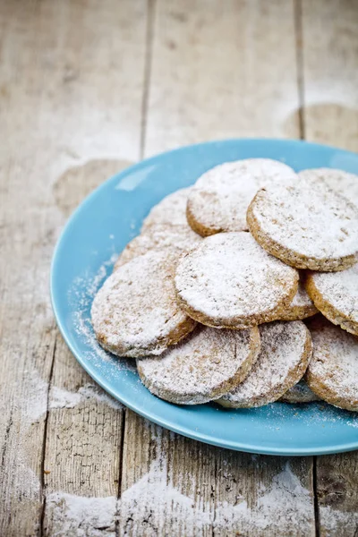 Biscotti di avena appena sfornati con zucchero in polvere su piatto di ceramica blu c — Foto Stock