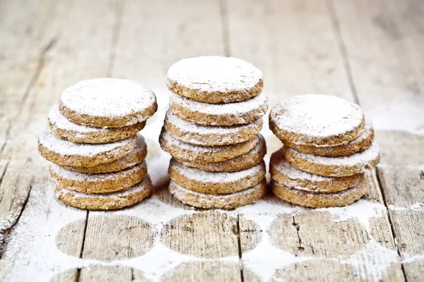 Fresh oat cookies stacks with sugar powder on rustic wooden tabl — Stock Photo, Image