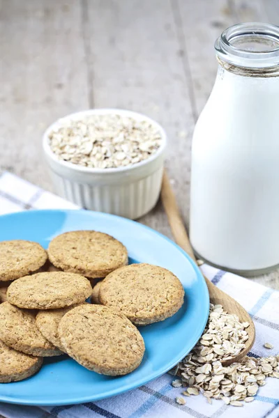 Biscotti di avena appena sfornati su piatto di ceramica blu su tovagliolo di lino, b — Foto Stock