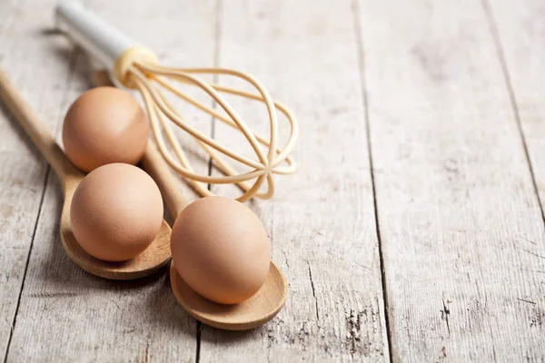 Huevos de pollo y utensilio de cocina sobre mesa de madera rústica backgrou —  Fotos de Stock