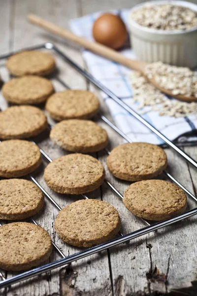 Grade de cozimento com biscoitos de aveia fresca na mesa de madeira rústica backgr — Fotografia de Stock