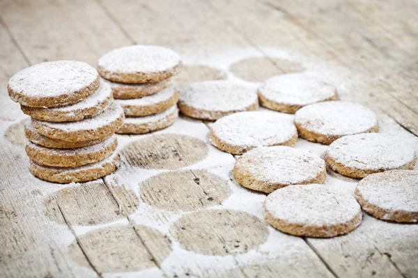 Biscotti di avena appena sfornati con zucchero in polvere sul tavolo di legno rustico — Foto Stock