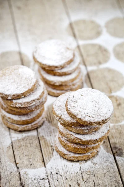 I biscotti di avena freschi impilano con polvere da zucchero su tabl di legno rustico — Foto Stock