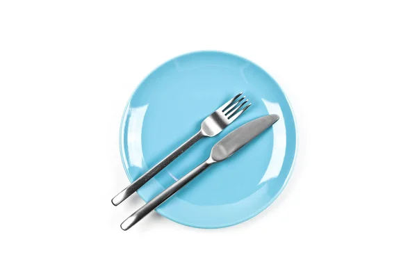 Набор пустой голубой тарелки, вилки и ножа на белом фоне . — стоковое фото