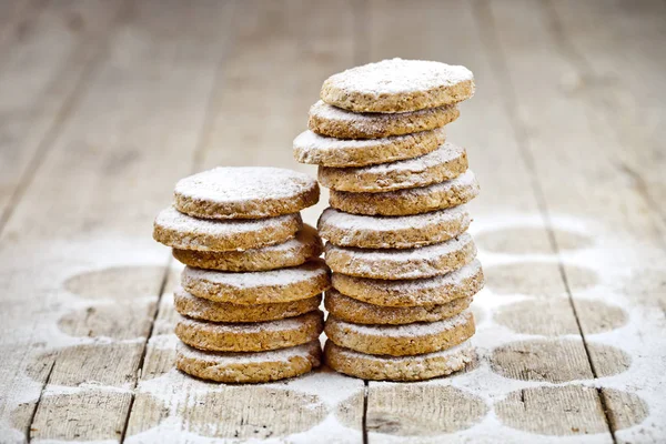 Fresh oat cookies stacks with sugar powder closeup on rustic woo — Stock Photo, Image