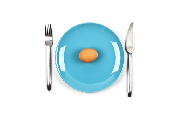 Fresh chicken boiled egg on blue plate, fork and knife on white — Stock Photo, Image