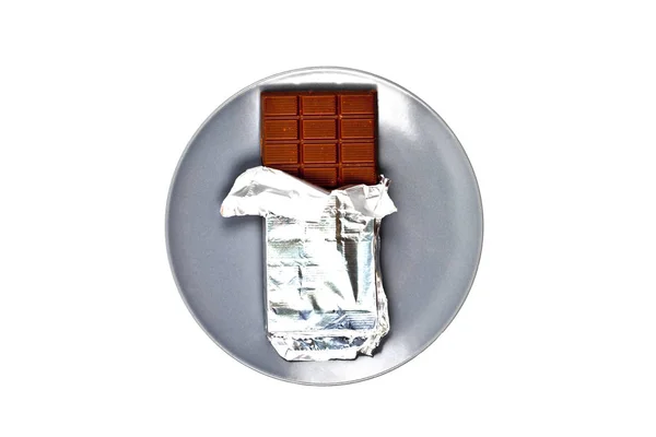 흰색에 고립 된 회색 세라믹 플레이트에 호일이있는 초콜릿 바 — 스톡 사진