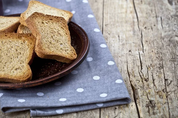 Rebanadas de pan de cereales tostados en placa de cerámica marrón primer plano en li — Foto de Stock