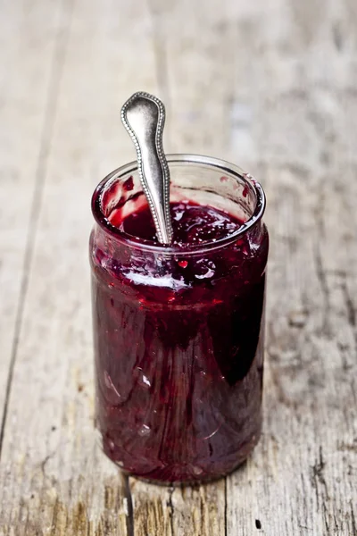 Fresh cherry homemade jam in jar on rustic wooden background. — Stock Photo, Image