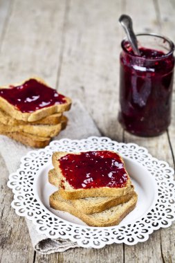 Beyaz tabak ve ev yapımı kavanoz üzerinde tost tahıl ekmek dilimleri