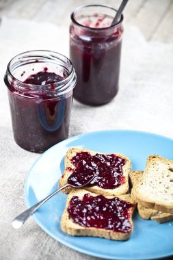 Mavi seramik tabakta taze tahıl lı ekmek dilimleri, ev yapımı kiraz