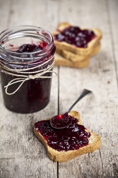 Geröstete Müslibrotscheiben und Glas mit hausgemachten Waldbeeren j — Stockfoto