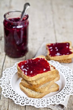 Beyaz tabak ve ev yapımı kavanoz üzerinde tost tahıl ekmek dilimleri