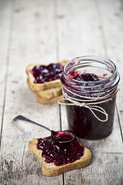 Toasted cereal bread slices and jar with homemade wild berries j — Stock Photo, Image