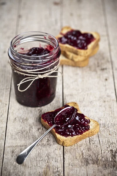 Toasted cereal bread slices and jar with homemade wild berries j — Stock Photo, Image