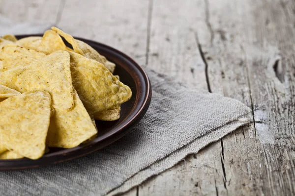 Chips nachos mexicanos em placa de cerâmica marrom na toalha de mesa de linho . — Fotografia de Stock