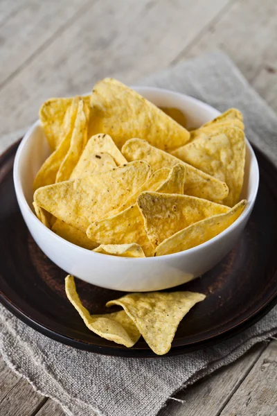 Fichas de nachos mexicanos en tazón blanco en placa de cerámica marrón en lin —  Fotos de Stock