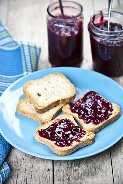 Rebanadas de pan de cereales frescos en plato de cerámica azul, cereza casera — Foto de Stock