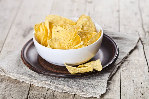 Fichas de nachos mexicanos en tazón blanco en placa de cerámica marrón en lin —  Fotos de Stock