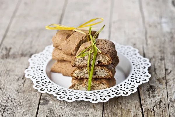 Biscotti freschi italiani cantuccini su piatto bianco su legno strutturato — Foto Stock