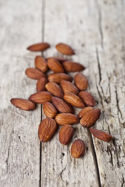 Pile of fresh organic almond seeds on rustick wooden table. — Stock Photo, Image