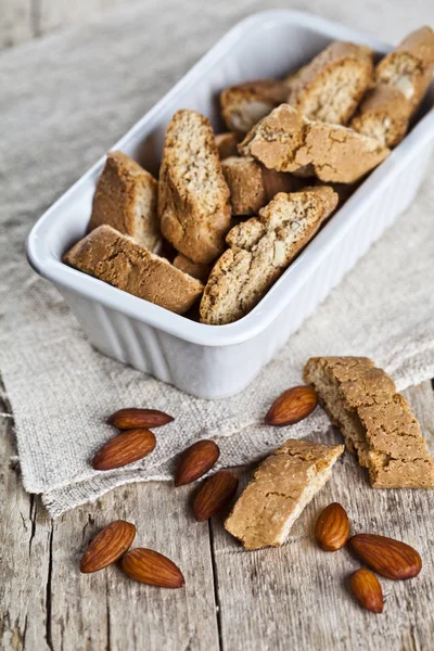 Cookies Cantuccini i vit keramisk skål och mandel frön på lin — Stockfoto