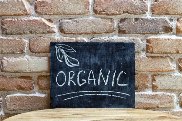 Chalk board with the word ORGANIC drown by hand and chalks on wo — Stock Photo, Image