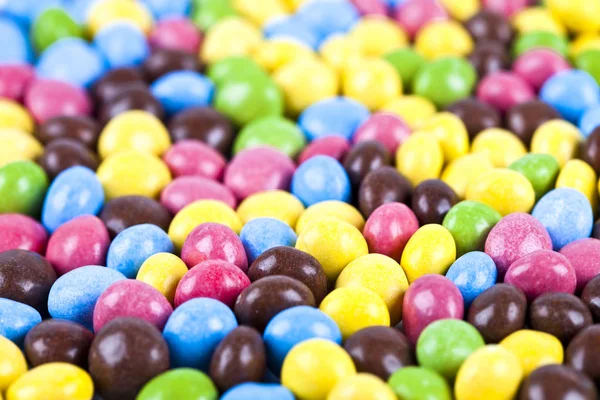 Pilha de deliciosos doces de chocolate coloridos ainbow . — Fotografia de Stock