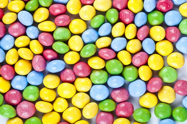 Pile of delicious rainbow colorful chocolate candies background. — Stock Photo, Image