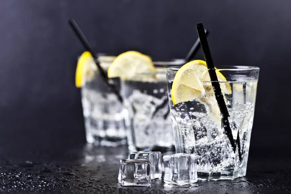 Tre bicchieri con acqua fresca fredda gassata con fette di limone — Foto Stock