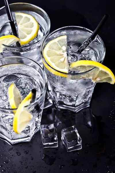 Tre bicchieri con acqua fresca fredda gassata con fette di limone — Foto Stock