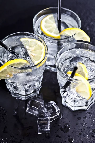 Tre bicchieri con acqua fresca fredda gassata con fette di limone — Foto Stock