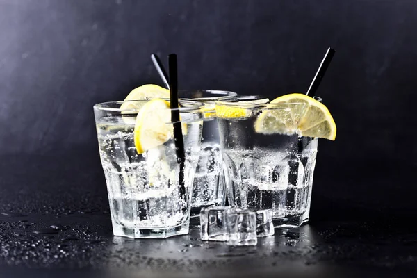 Three glasses of fresh cold carbonated water with ice cubes and — Stock Photo, Image