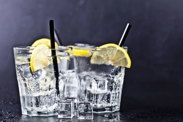 Три стакана с холодной газированной водой и ломтиками лимона — стоковое фото