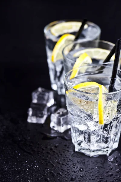 Три склянки зі свіжою холодногазованою водою зі скибочками лимона — стокове фото