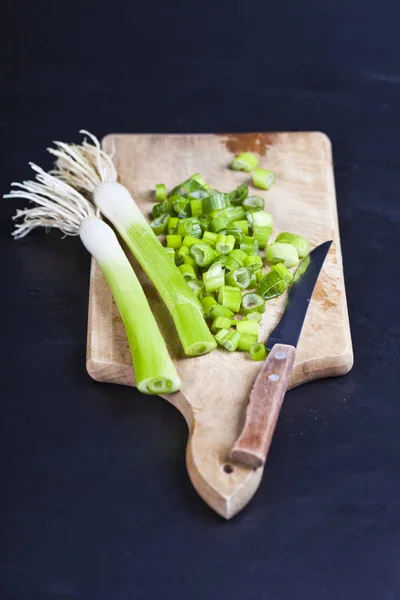 Fresh green organic chopped onions and knife on a cutting board. — Stock Photo, Image