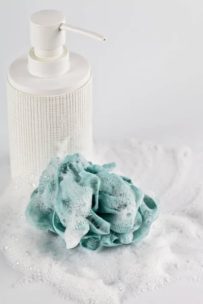 Liquid soap, green sponge and foam on light background. — Stock Photo, Image