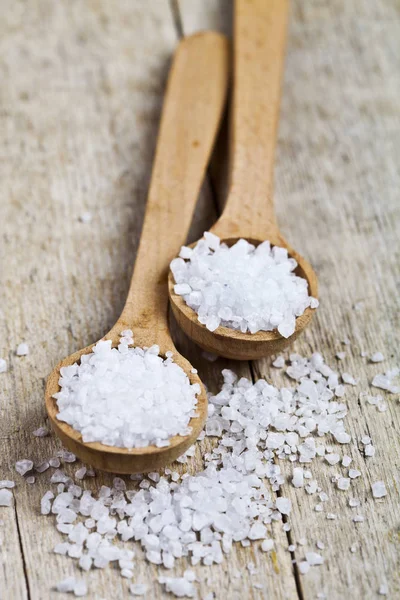 Wooden spoons with sea salt closeup on wooden rustic table. — Stock Photo, Image