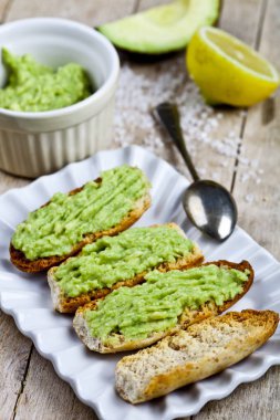 Rustik w Beyaz plaka çekim üzerinde avokado guacamole ile tost
