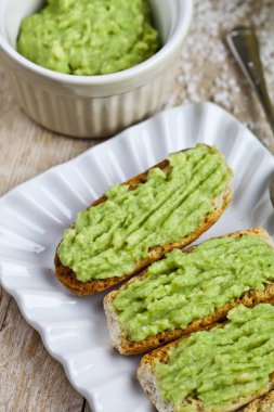 Beyaz plaka üzerinde avokado guacamole ile taze crostini 
